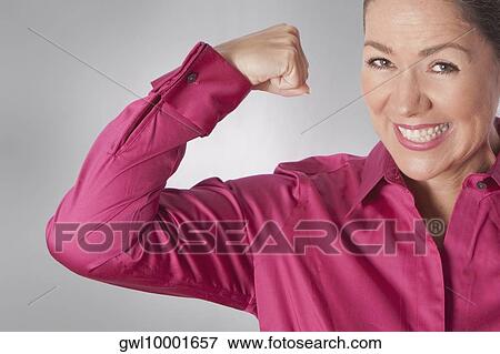 Stock Photo - Portrait of a woman flexing her muscles and smiling. Fotosearch