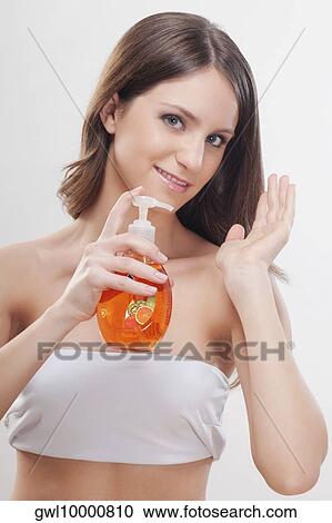 Portrait of a woman holding a bottle of liquid soap View Large Photo Image Stock Image - Portrait of a woman holding a bottle of liquid soap . Fotosearch