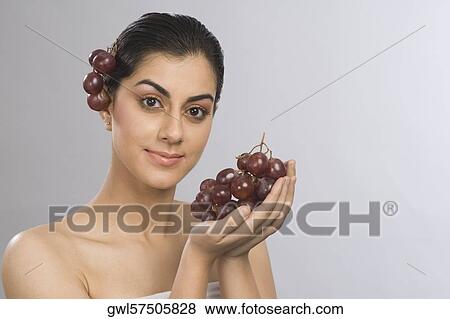 Portrait of a woman holding a bunch of red grapes View Large Photo Image Stock Photo - Portrait of a woman holding a bunch of red grapes. Fotosearch