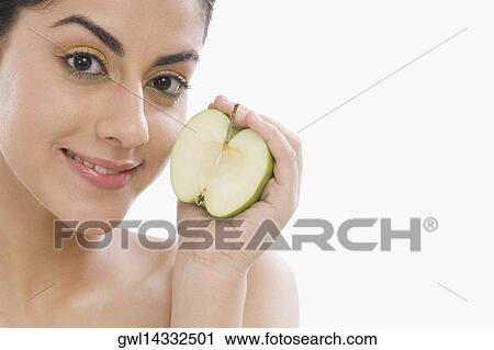 Portrait of a woman holding a half of green apple View Large Photo Image Stock Image - Portrait of a woman holding a half of green apple. Fotosearch