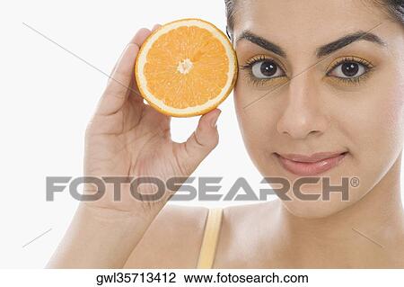 Portrait of a woman holding a half of orange View Large Photo Image Stock Image - Portrait of a woman holding a half of orange. Fotosearch