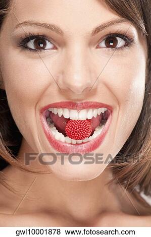 Portrait of a woman holding a raspberry in her mouth View Large Photo Image Stock Photo - Portrait of a woman holding a raspberry in her mouth. Fotosearch