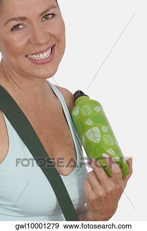 Stock Photo - Portrait of a woman holding a water bottle and smiling. Fotosearch