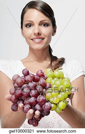 Portrait of a woman holding green and red grapes View Large Photo Image Stock Image - Portrait of a woman holding green and red grapes. Fotosearch