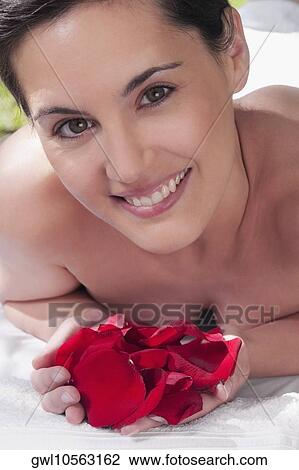 Portrait of a woman lying on a massage table holding rose petals View Large Photo Image Stock Image - Portrait of a woman lying on a massage table holding rose petals. Fotosearch