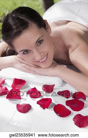 Portrait of a woman lying on a massage table with rose petals View Large Photo Image Stock Image - Portrait of a woman lying on a massage table with rose petals. Fotosearch