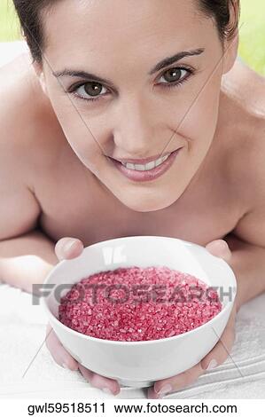 Portrait of a woman lying on a massage table and holding a bowl of bath salt View Large Photo Image Stock Image - Portrait of a woman lying on a massage table and holding a bowl of bath salt. Fotosearch