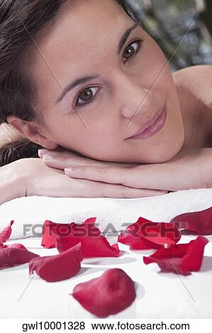 Portrait of a woman lying on a massage table with rose petals View Large Photo Image Stock Photo - Portrait of a woman lying on a massage table with rose petals. Fotosearch