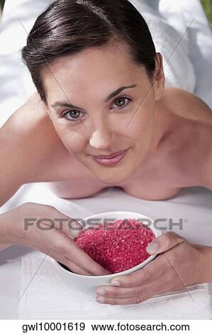 Portrait of a woman lying on a massage table and holding a bowl of bath salt View Large Photo Image Stock Photo - Portrait of a woman lying on a massage table and holding a bowl of bath salt. Fotosearch