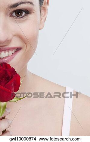 Picture - Portrait of a woman smelling a rose . Fotosearch