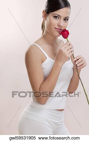 Stock Photography - Portrait of a woman smelling a rose. Fotosearch