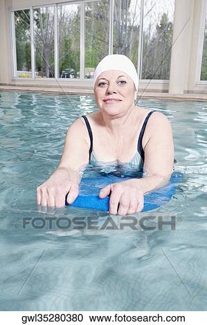Portrait of a woman swimming with a float in a swimming pool View Large Photo Image Stock Image - Portrait of a woman swimming with a float in a swimming pool. Fotosearch