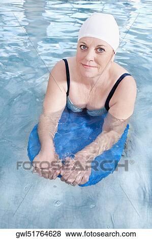 Portrait of a woman swimming with a float in a swimming pool View Large Photo Image Stock Photo - Portrait of a woman swimming with a float in a swimming pool. Fotosearch