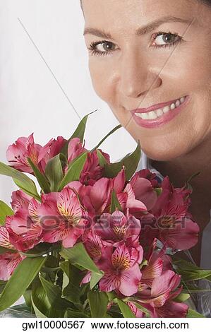 Portrait of a woman with bunch of flowers View Large Photo Image Stock Photo - Portrait of a woman with bunch of flowers. Fotosearch