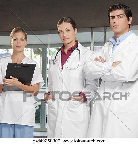 Portrait of three doctors standing together View Large Photo Image Stock Photo - Portrait of three doctors standing together. Fotosearch