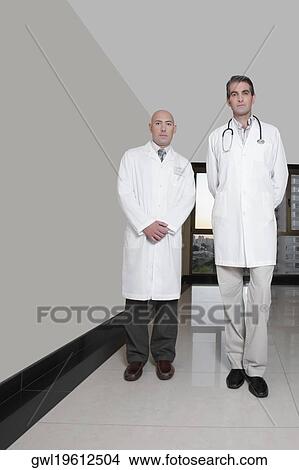 Portrait of two male doctors standing in a hospital corridor View Large Photo Image Picture - Portrait of two male doctors standing in a hospital corridor. Fotosearch
