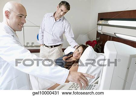 Stock Image - Pregnant woman going through an ultrasound scan. Fotosearch