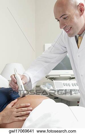 Stock Image - Pregnant woman going through an ultrasound scan. Fotosearch