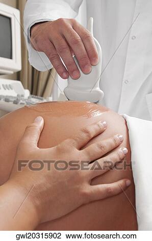 Pregnant woman going through an ultrasound scan View Large Photo Image Stock Image - Pregnant woman going through an ultrasound scan. Fotosearch