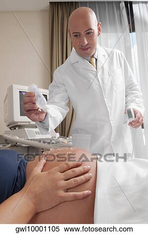 Pregnant woman going through an ultrasound scan View Large Photo Image Stock Photography - Pregnant woman going through an ultrasound scan. Fotosearch