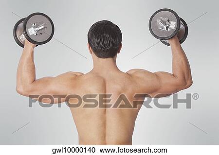 Rear view of a man exercising with dumbbells View Large Photo Image Stock Image - Rear view of a man exercising with dumbbells. Fotosearch
