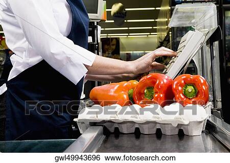 Stock Photograph - Sales clerk using a cash register at a checkout counter. Fotosearch