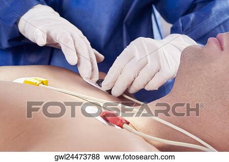 Surgeon attaching ECG electrodes on patient's chest View Large Photo Image Stock Photo - Surgeon attaching ECG electrodes on patient's chest. Fotosearch