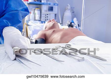 Surgeon holding surgical scissors in an operating room View Large Photo Image Stock Photo - Surgeon holding surgical scissors in an operating room. Fotosearch
