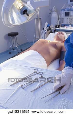 Surgeon holding surgical scissors in an operating room View Large Photo Image Stock Photography - Surgeon holding surgical scissors in an operating room. Fotosearch