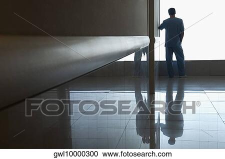 Surgeon looking through a window in a hospital View Large Photo Image Stock Image - Surgeon looking through a window in a hospital. Fotosearch