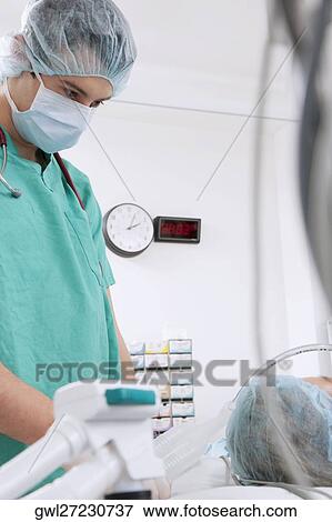 Stock Photo - Surgeon performing a surgery in an operating room. Fotosearch