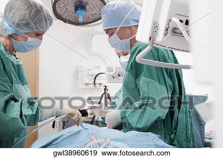 Stock Photo - Surgeon performing a surgery in an operating room. Fotosearch
