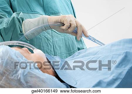Surgeon performing a surgery in an operating room View Large Photo Image Stock Photo - Surgeon performing a surgery in an operating room. Fotosearch