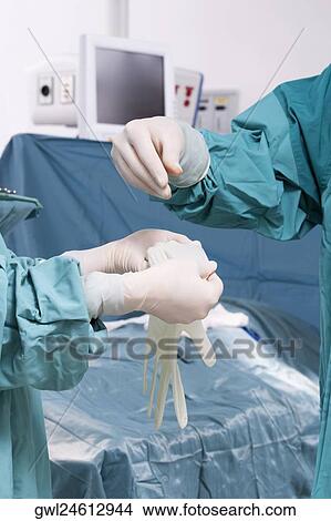 Picture - Surgeon putting on surgical gloves. Fotosearch
