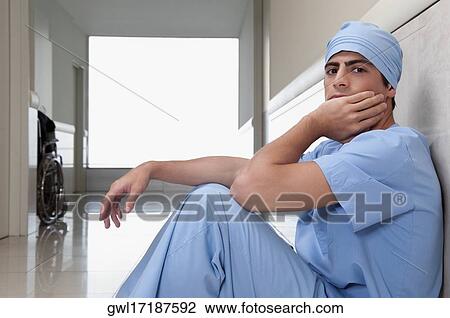 Surgeon sitting on the floor in a hospital View Large Photo Image Stock Image - Surgeon sitting on the floor in a hospital. Fotosearch