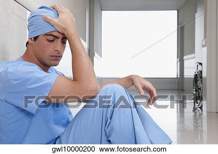 Surgeon sitting on the floor looking depressed View Large Photo Image Stock Image - Surgeon sitting on the floor looking depressed. Fotosearch