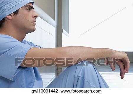 Surgeon sitting on the floor looking serious View Large Photo Image Stock Image - Surgeon sitting on the floor looking serious. Fotosearch