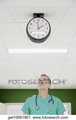 Stock Image - Surgeon standing in a hospital corridor. Fotosearch