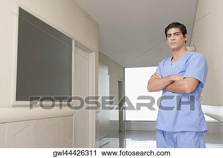 Surgeon standing in the corridor of a hospital View Large Photo Image Stock Image - Surgeon standing in the corridor of a hospital. Fotosearch