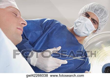 Surgeon with a patient in an operating room View Large Photo Image Stock Photo - Surgeon with a patient in an operating room. Fotosearch