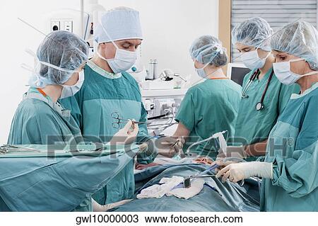 Stock Image - Surgeons performing a surgery in an operating room. Fotosearch