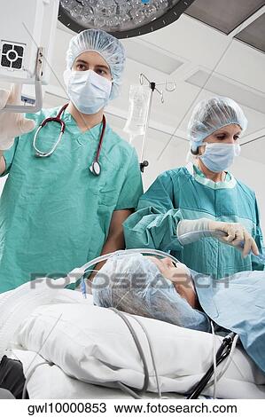 Surgeons performing a surgery in an operating room View Large Photo Image Stock Image - Surgeons performing a surgery in an operating room. Fotosearch