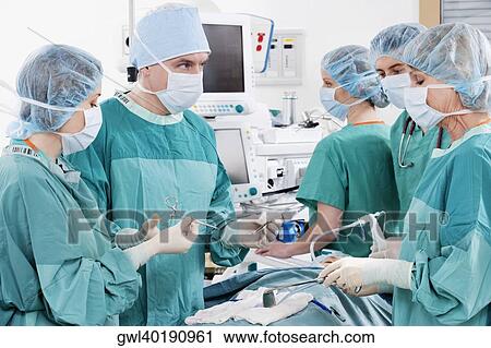 Stock Image - Surgeons performing a surgery in an operating room. Fotosearch