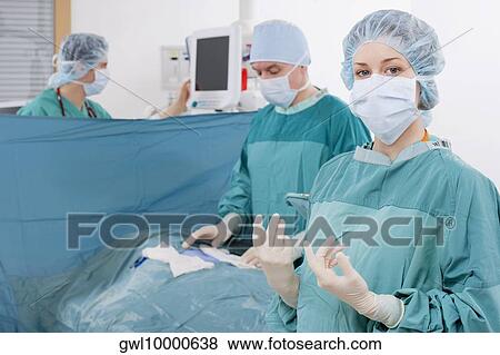 Surgeons performing a surgery in an operating room View Large Photo Image Stock Photo - Surgeons performing a surgery in an operating room. Fotosearch