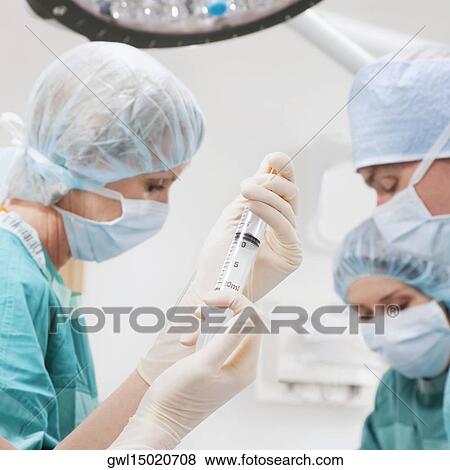 Surgeons performing a surgery in an operating room View Large Photo Image Stock Photo - Surgeons performing a surgery in an operating room. Fotosearch