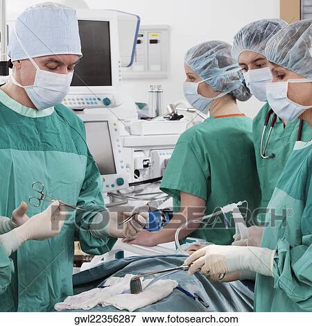 Surgeons performing a surgery in an operating room View Large Photo Image Stock Photo - Surgeons performing a surgery in an operating room. Fotosearch