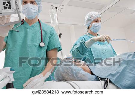 Stock Photo - Surgeons performing a surgery in an operating room. Fotosearch