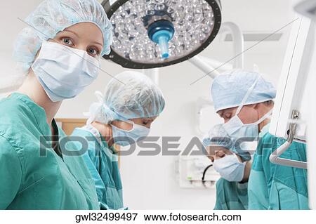 Surgeons performing a surgery in an operating room View Large Photo Image Stock Photo - Surgeons performing a surgery in an operating room. Fotosearch