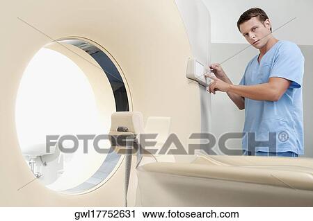 Technician operating an MRI scanner View Large Photo Image Stock Image - Technician operating an MRI scanner. Fotosearch