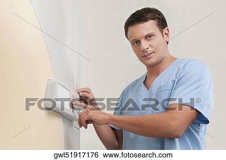 Stock Photograph - Technician operating an MRI scanner. Fotosearch